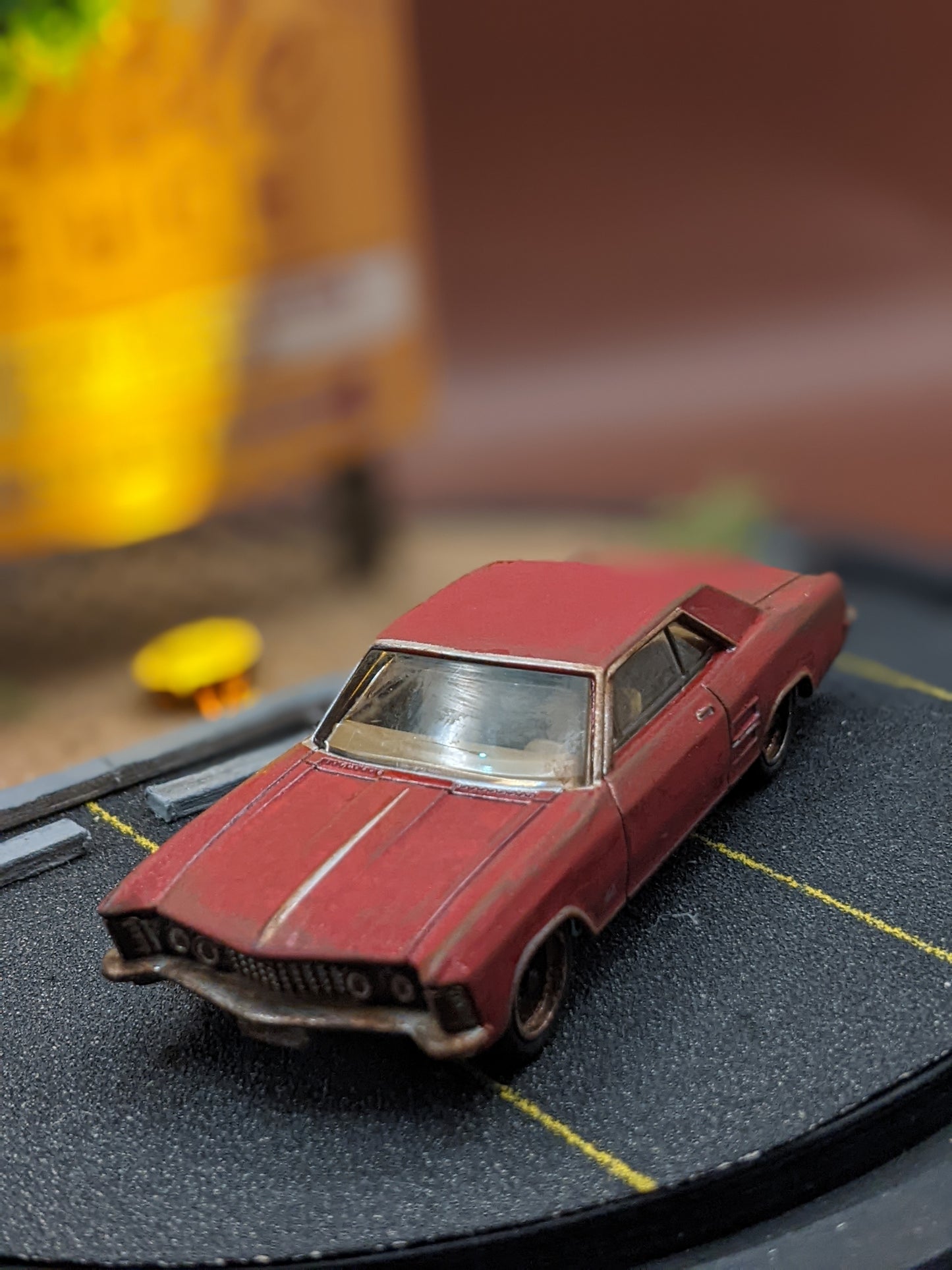 Close-up of miniature 1:64 scale car and illuminated sign inside handmade movie scene lamp.