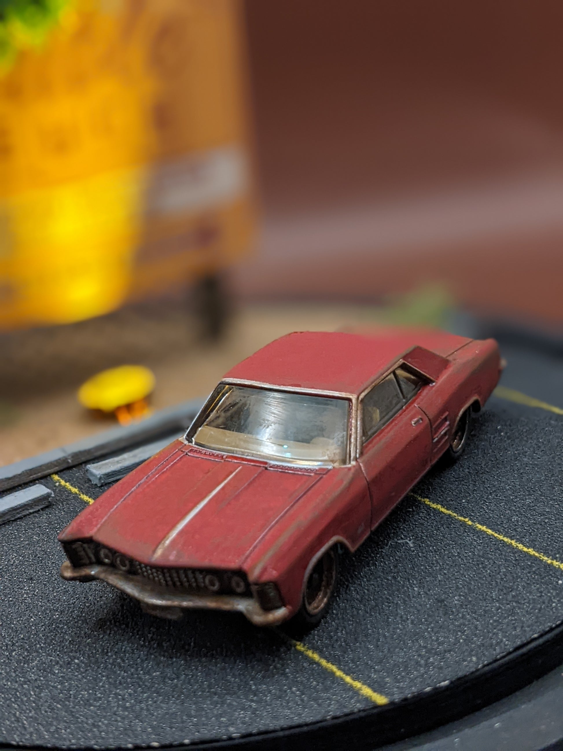 Close-up of miniature 1:64 scale car and illuminated sign inside handmade movie scene lamp.