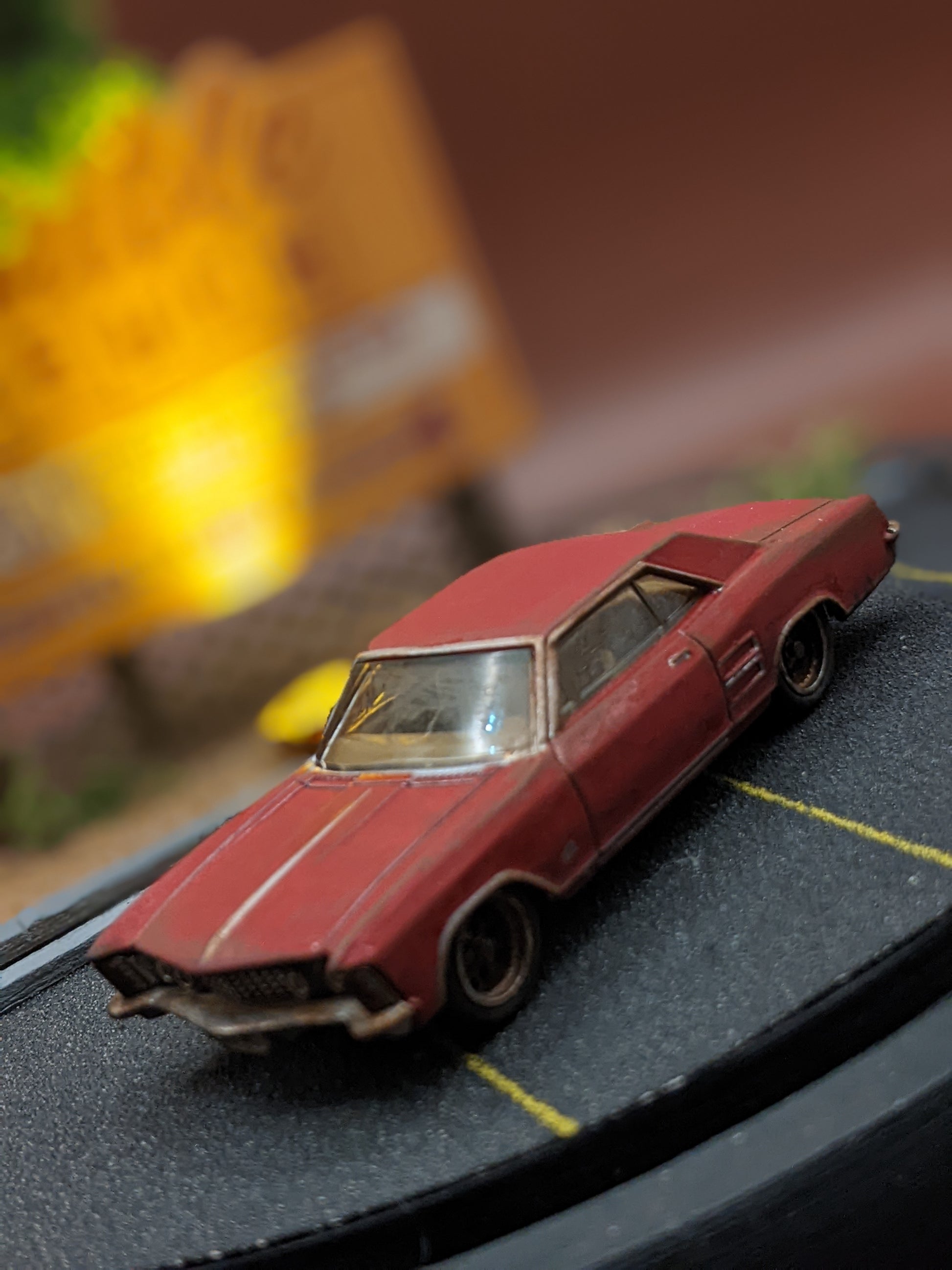 Red model car on a miniature road with blurred background