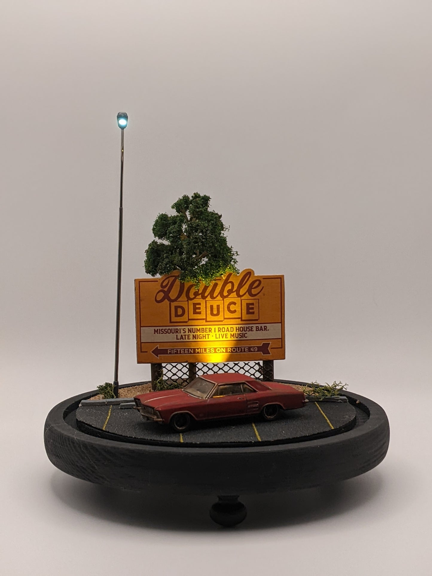 Model of a billboard with 'Double Deuce' and a car below on a gray background
