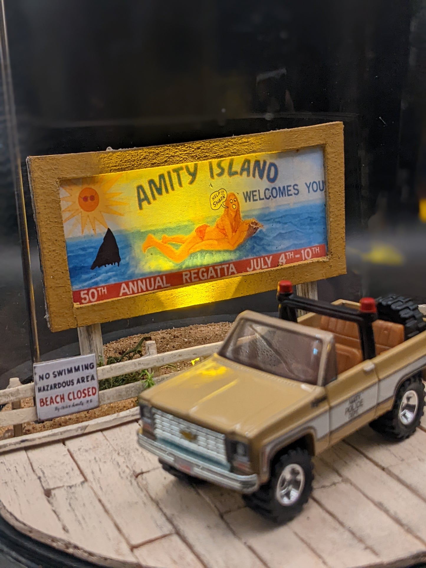 Jaws collectible bell jar lamp glowing softly, showing the Amity Island boardwalk scene at night.