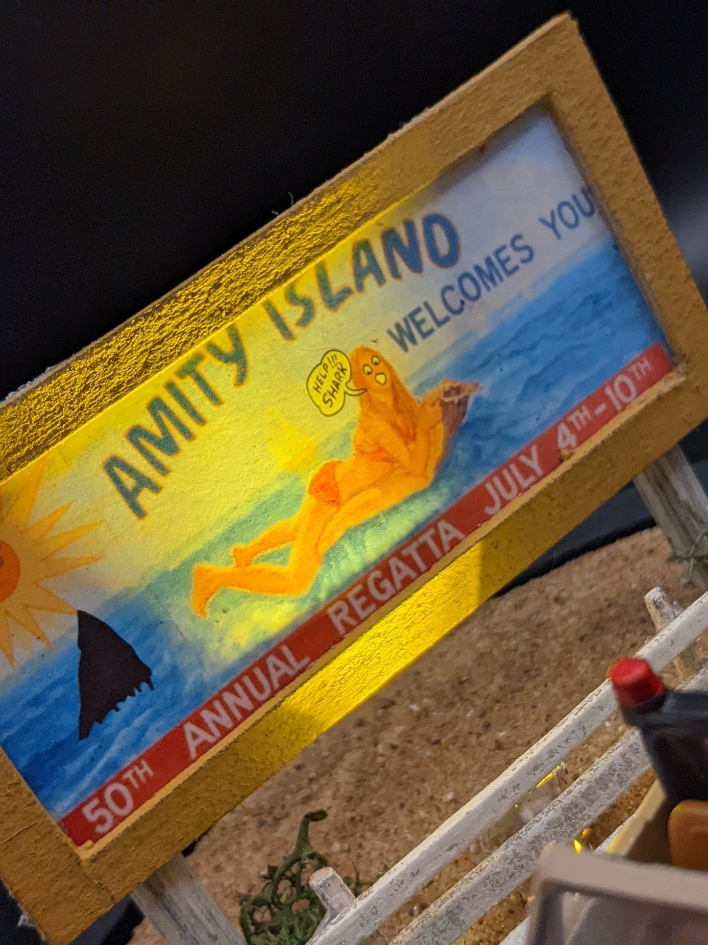 Close-up of illuminated Amity Island billboard in handmade movie diorama lamp.